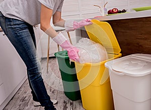 Young girl sorting garbage at the kitchen. Concept of recycling. Zero waste