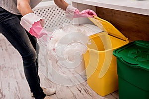 Young girl sorting garbage at the kitchen. Concept of recycling. Zero waste