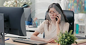 Young girl spends morning in front of computer in office taking care of chores speaks on phone with client making