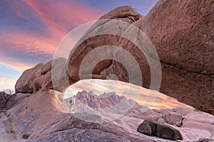 Young girl in Spitzkoppe area with picturesque stone arches and unique rock formations in Damaraland Namibia