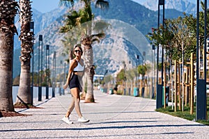 A young girl in sportswear is going to workout with a fitness mat