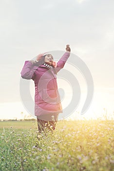 Young girl spreading hands and joy with nature while winter time