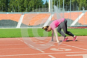 A young girl in the stadium is preparing to start