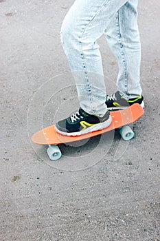 young girl stand on a penny board. resting in the park while skateboarding