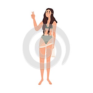 Young girl standing in bikini, beachwear. Happy slim thin woman in swimwear gesturing peace victory sign. Modern female