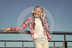 Young girl standing on bridge. Music lover. Happy childhood. Enjoying melody. Fashionable look. Music as favourite hobby