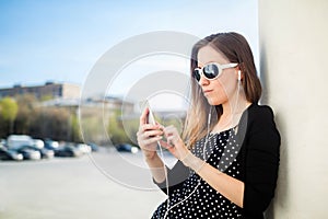 Young girl standing on the college campus yard leaning oncolumn