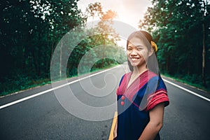 Young girl standing and enjoy fresh air on road at countryside of Thailand