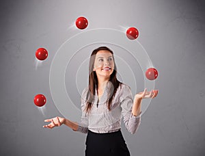 Young girl standing and juggling with red balls