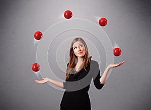 Young girl standing and juggling with red balls