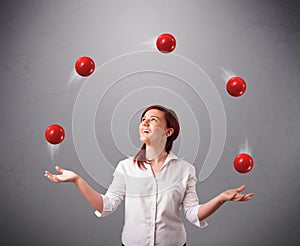 Young girl standing and juggling with red balls