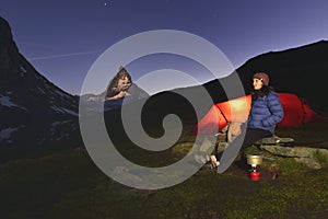 Young girl stands near her tent with the Matterhorn 4478m peak in background.