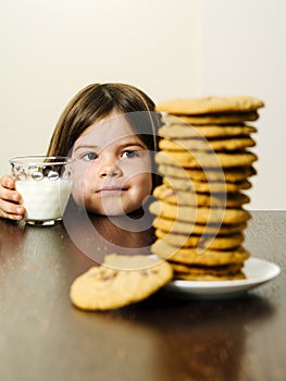 Young girl staring at pile of cookies