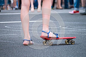 Young girl starts to drive on skateboard in the shadow. Outdoors