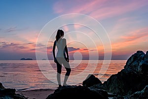 Young girl stay on the beach and watching the sunset