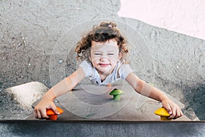 A young girl struggles to climb a game in a playground