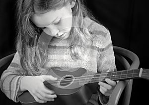 Young girl strumming instrument