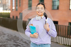 Young Girl Student Holding Book and Headphones