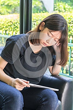Young girl studying online from digital tablet in parlor