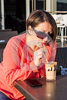 Young Girl With Sunglasses Drinking Coffee and Enjoying Beautiful Sunny Day Outside