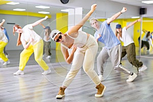 Young girl in sunglasses training breakdance Toprock moves in dance hall