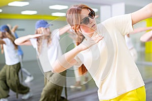 Young girl in sunglasses training breakdance Toprock moves in dance hall