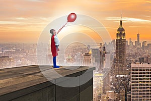 The young girl in superhero costume overlooking the city