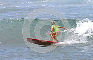 Young Girl Surfing on a Red Surfboard in Hawaii