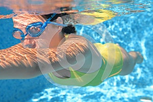 Young girl swimmer swimming freestyle in pool, under water view, sport and fitness