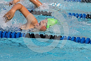 Young Girl swimming freestyle in race