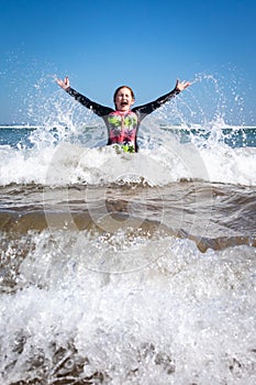 Young girl swimming and having fun in the sea at a surf beach in New Zealand