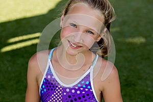 Young girl in a swimsuit on a shelf by the pool