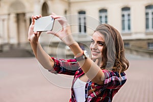 Young girl take selfie from hands with phone on summer city street urban life concept