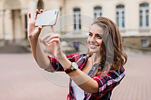 Young girl take selfie from hands with phone on summer city street urban life concept