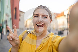 Young girl take selfie from hands with phone on summer city street. Urban life concept. Krakow, Poland
