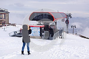 A young girl takes a photo of the cableway in the High Tatras