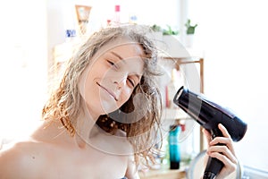 Young girl taking care of her hairs in a bathroom