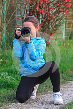 Young girl taking photography classes at countryside holding camera in hands