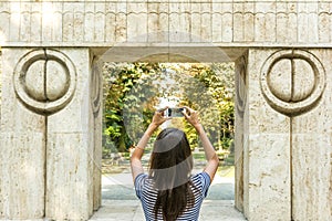 Young Girl Taking Photography Of The Gate of the Kiss