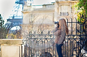 Young girl taking picture of the Eiffel tower