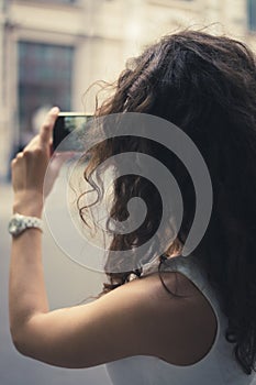 Young girl taking pictures on a phone