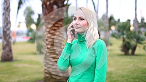 Young girl talking on mobile cell phone smiling, outdoors. Happy Woman