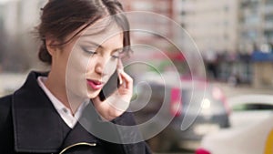 Young girl talking on mobile cell phone smiling, outdoors. Happy Woman Talking On Smart Phone in the street