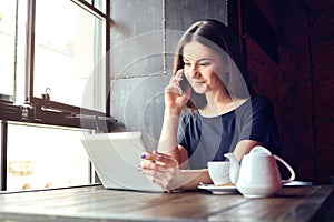 Young girl talking on mobile phone in coffee shop