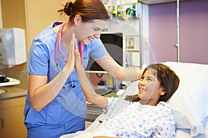 Young Girl Talking To Female Nurse In Hospital Room