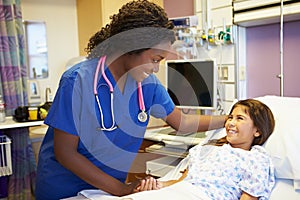 Young Girl Talking To Female Nurse In Hospital Room