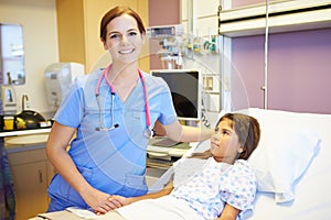 Young Girl Talking To Female Nurse In Hospital Room