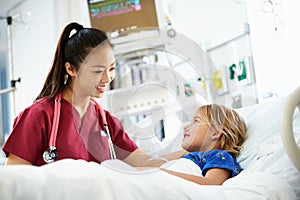 Young Girl Talking To Female Nurse In Intensive Care Unit