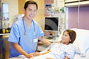 Young Girl Talking To Male Nurse In Hospital Room