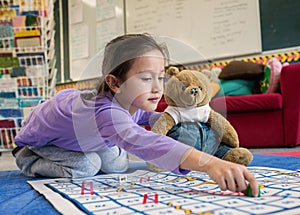 Young Girl and Teddy Playing Snakes and Ladders